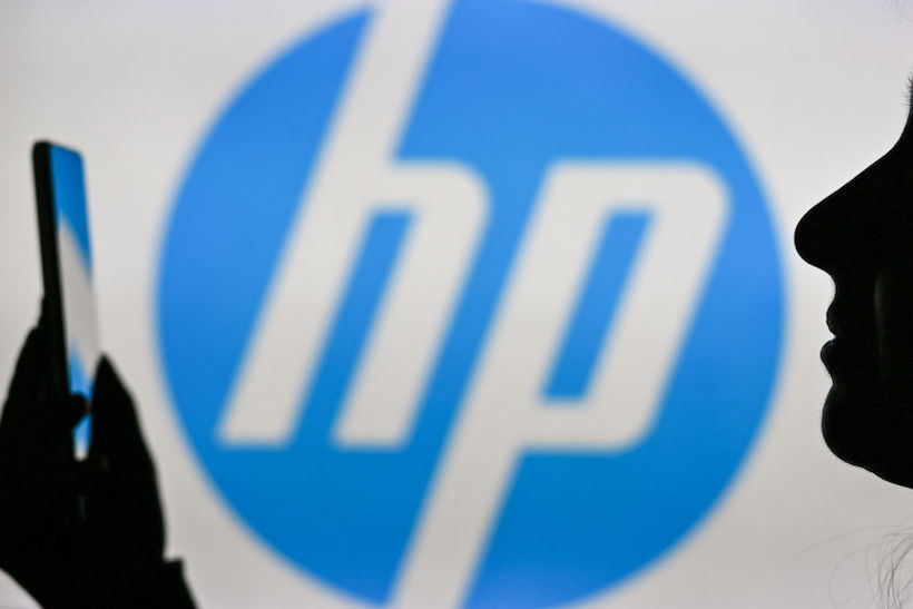 Person holding smart phone in front of HP logo