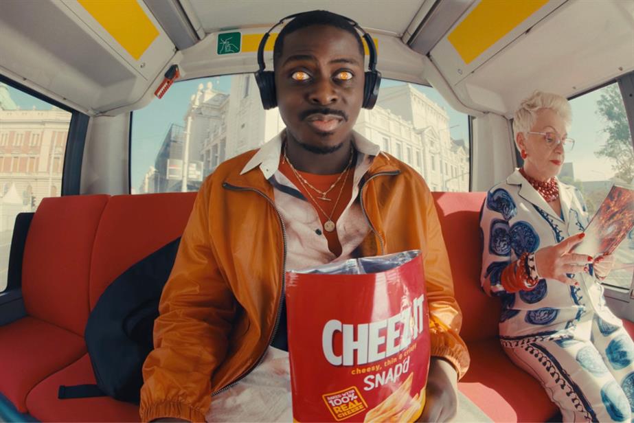 Man sat on a bus eating Cheez-It snack