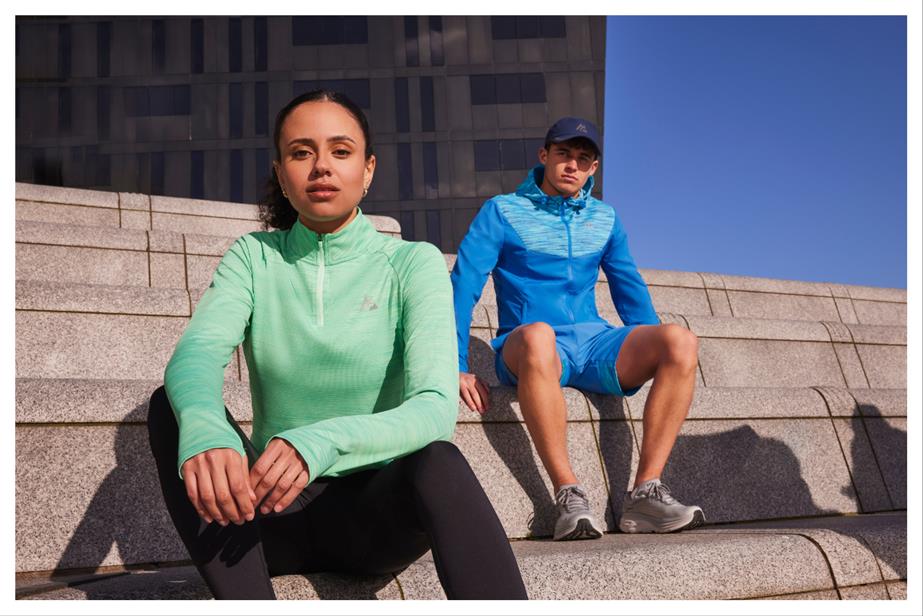 A woman and a man wearing workout gear sit looking into the camera